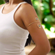Gold spiral arm cuff bracelet with turquoise stones styled on a woman’s upper arm, combining boho-chic and Afrocentric elegance.