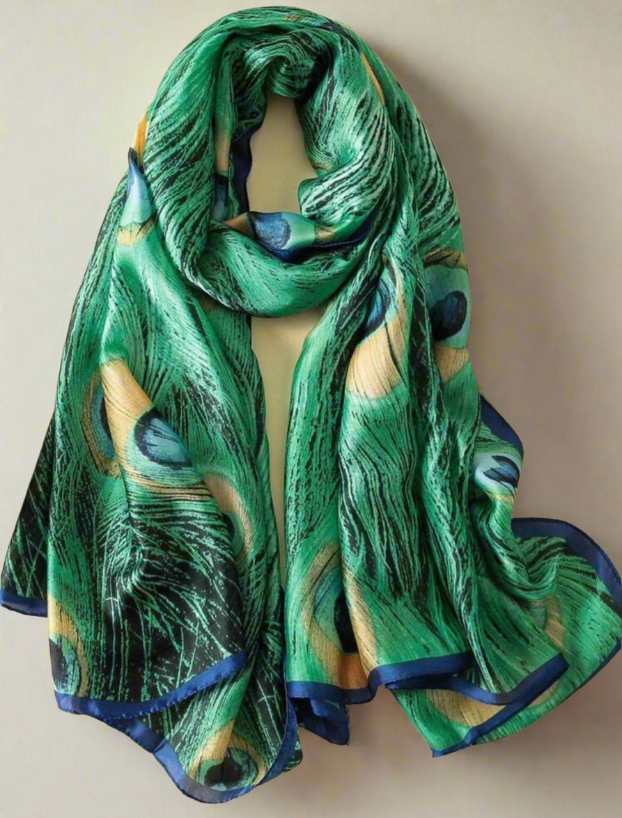 Luxurious green peacock feather scarf with royal blue trim, made from silky, lightweight fabric, perfect as a headwrap, shawl, or statement accessory for elegant styling