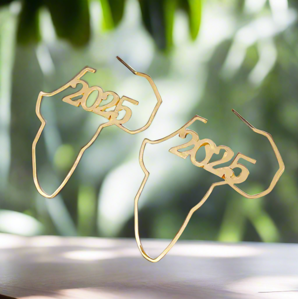 The Zanzibar Africa Map Gold Earrings by Desiree W.A.R Store are crafted in gold-tone metal, featuring 2025 at the center to celebrate African heritage with timeless elegance.